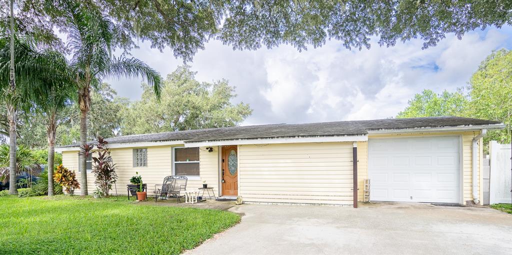 front view of a house with a yard and an trees