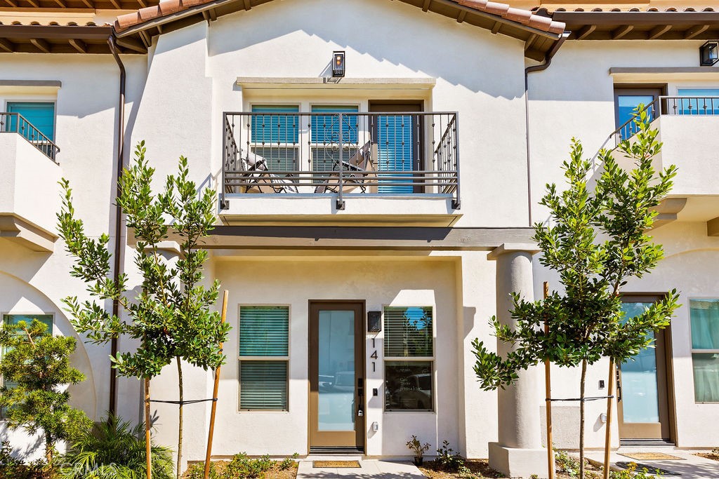 a front view of a house with a tree