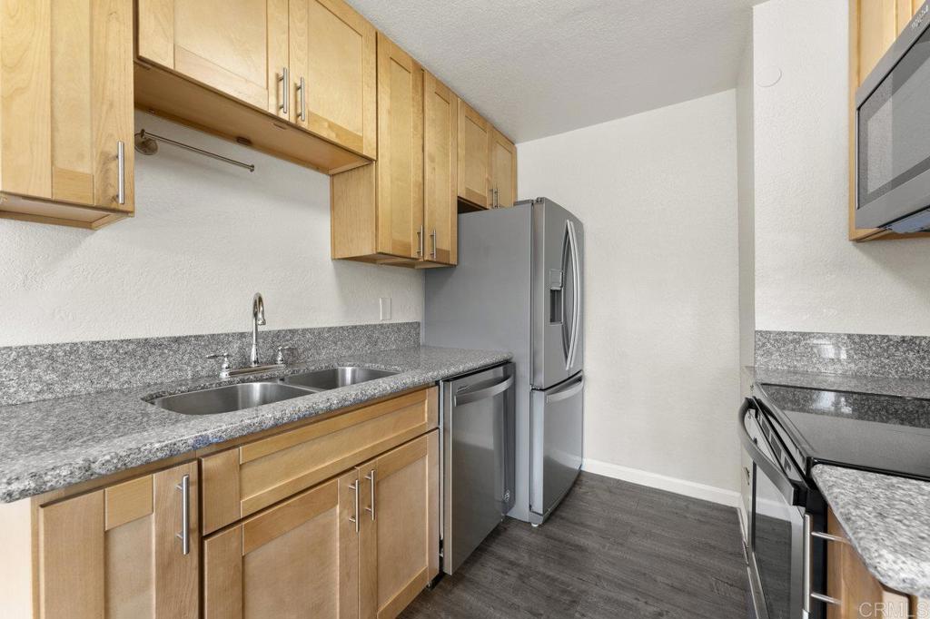 a kitchen with stainless steel appliances granite countertop a sink stove and refrigerator