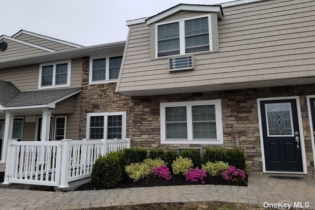 a front view of a house with a garden and seating space