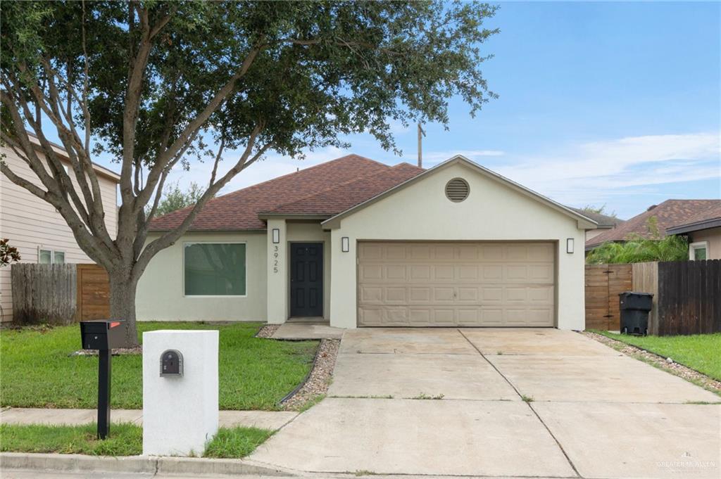 Single story home with a garage and a front yard