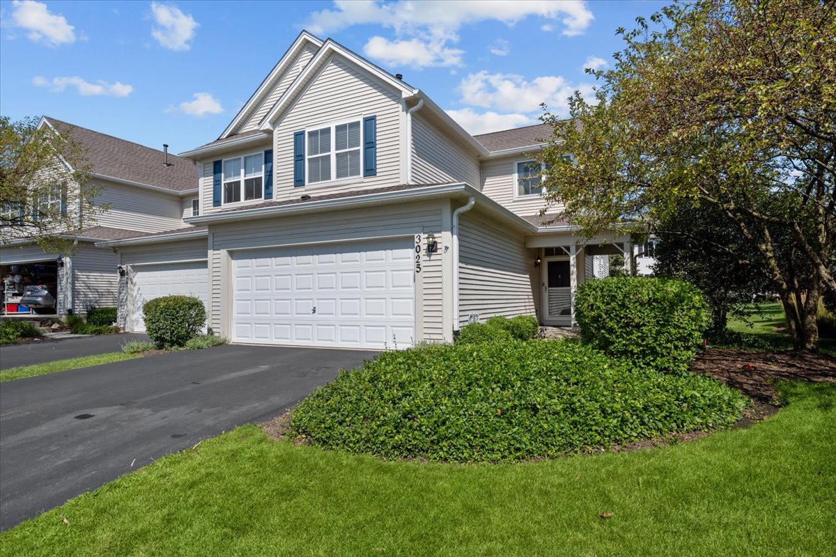 a front view of a house with a yard and garage