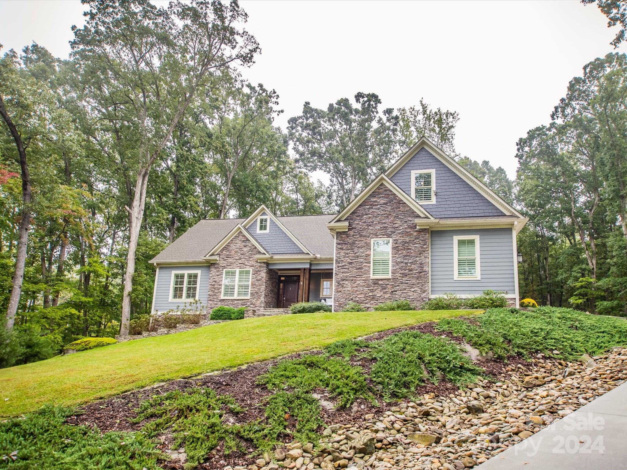 a front view of a house with yard and green space