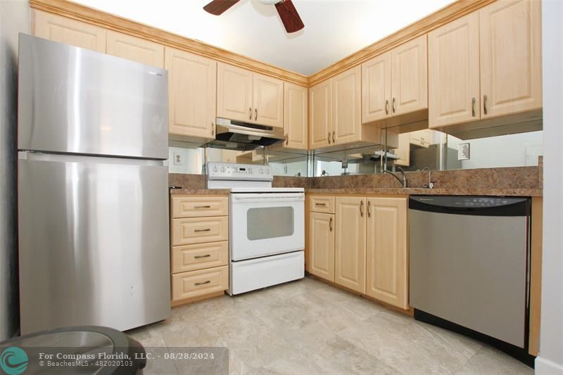 a kitchen with white cabinets and white appliances