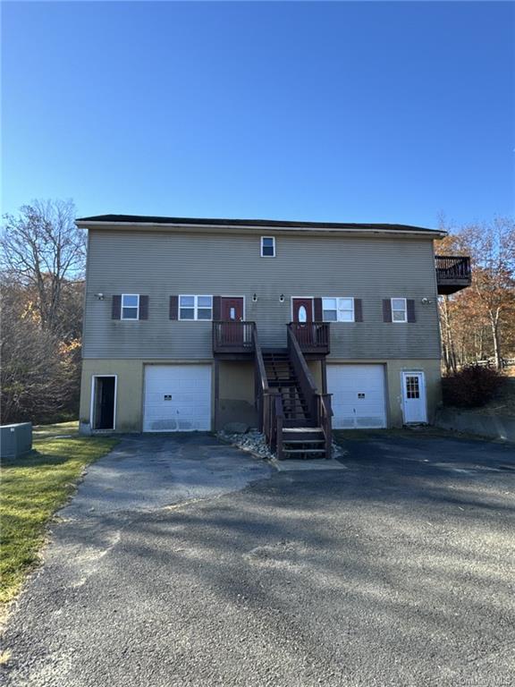 Rear view of property with central AC and a garage