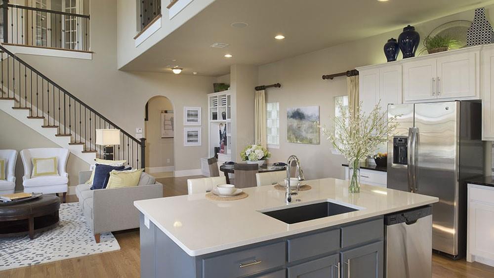 a kitchen with stainless steel appliances kitchen island granite countertop a sink and refrigerator