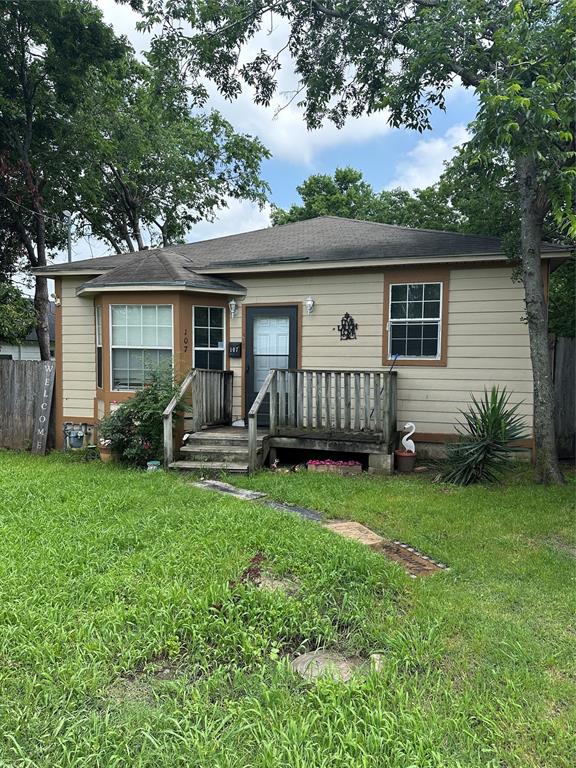 a view of backyard of house with deck and garden