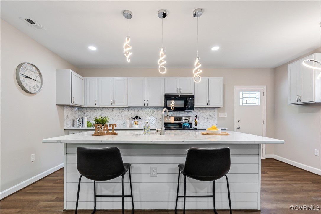 a kitchen with stainless steel appliances a dining table chairs and a refrigerator