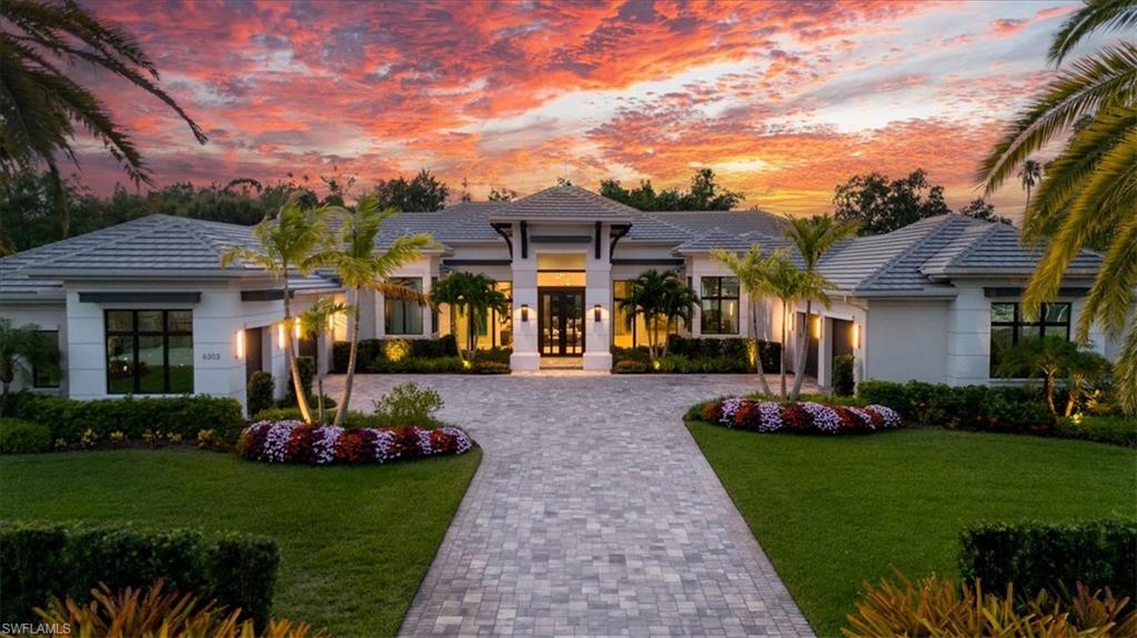 a front view of a house with a garden and plants