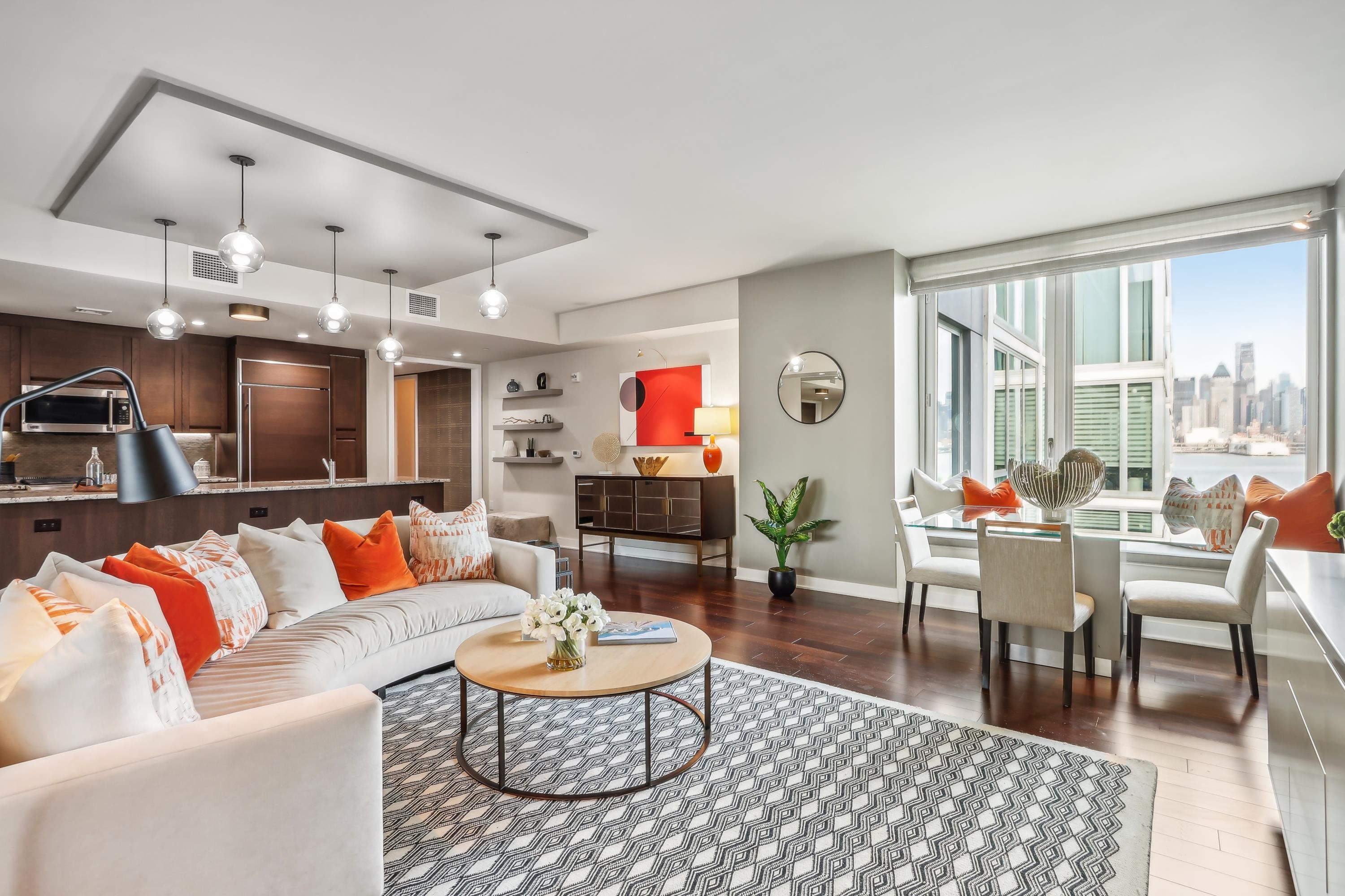 a living room with furniture kitchen view and a large window