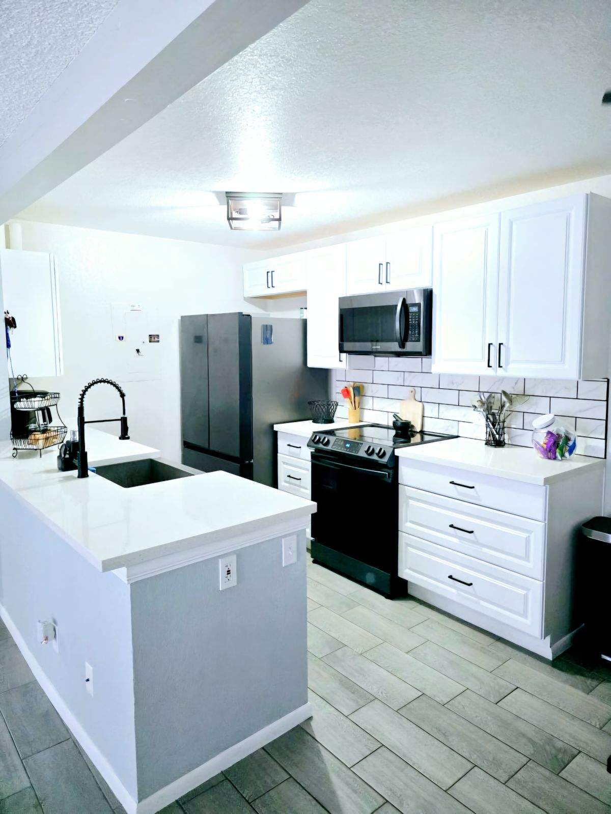 a kitchen with kitchen island a white counter top space and stainless steel appliances