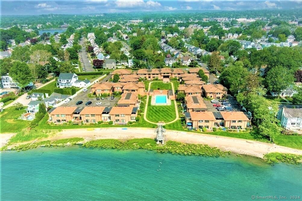 an aerial view of residential houses with outdoor space and trees