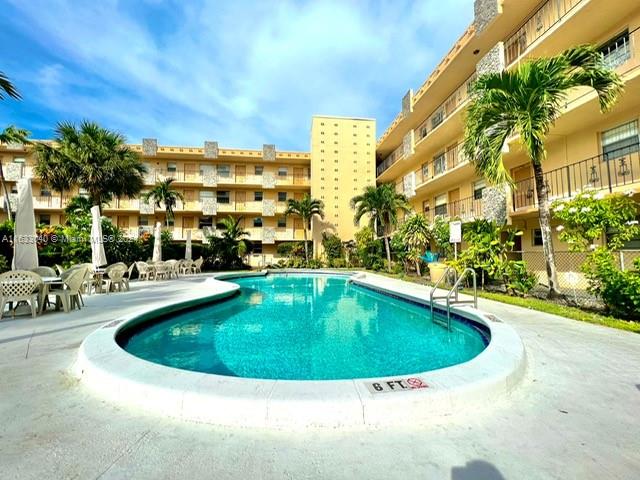 a view of swimming pool with outdoor seating and plants