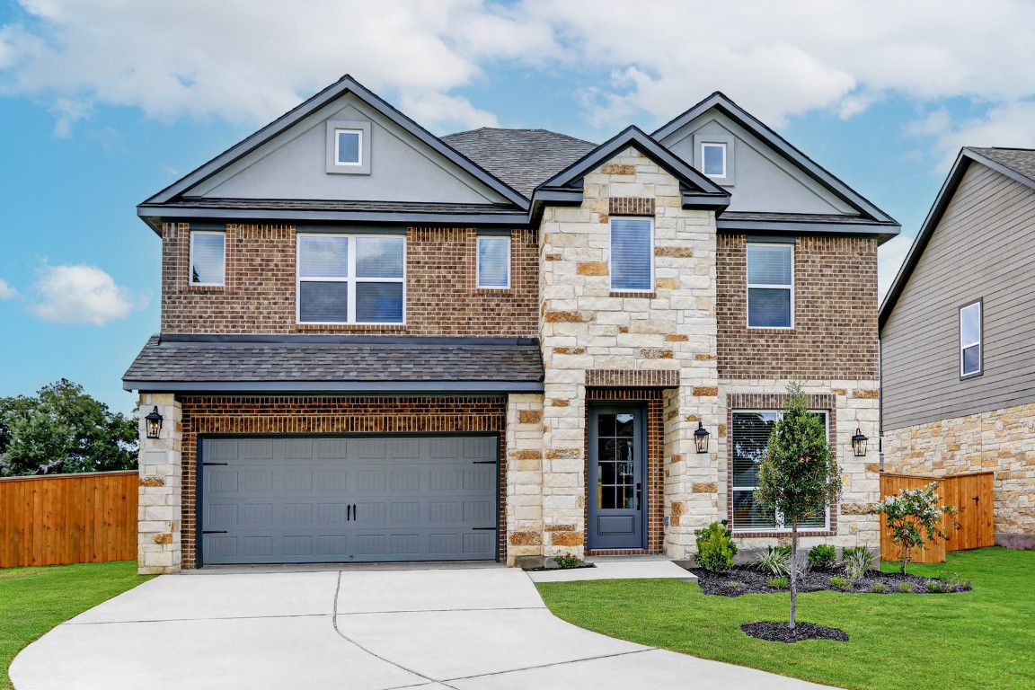 a front view of a house with a yard and garage