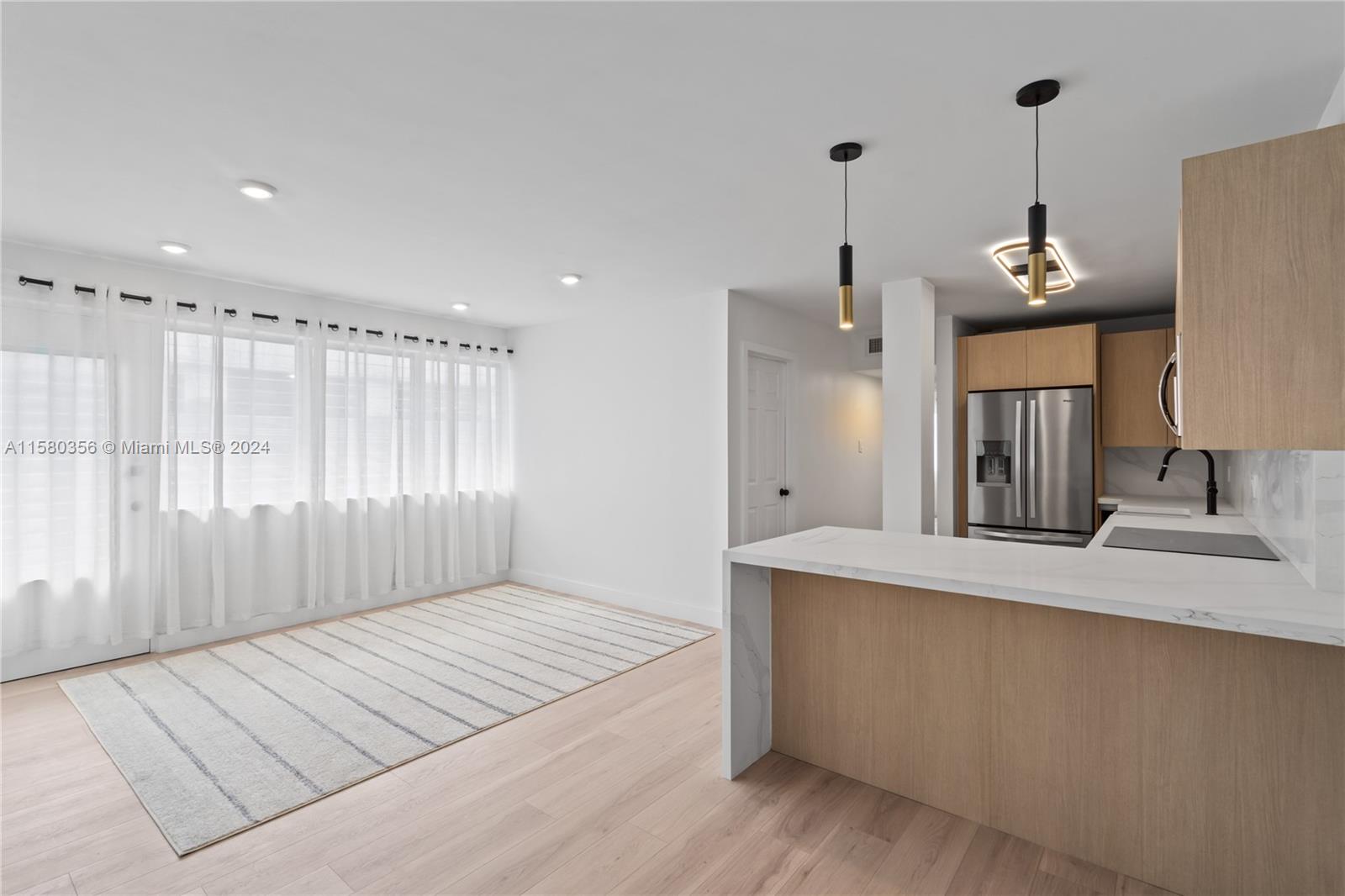 a large white kitchen with a sink and dishwasher