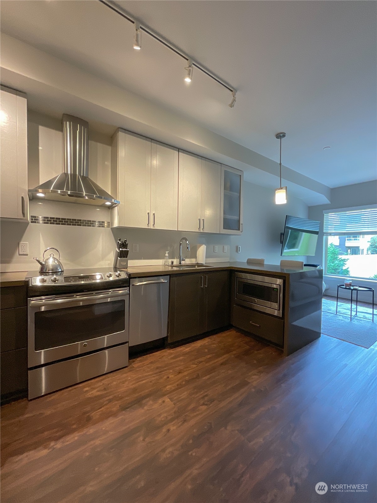 a kitchen with kitchen island granite countertop a stove and a sink