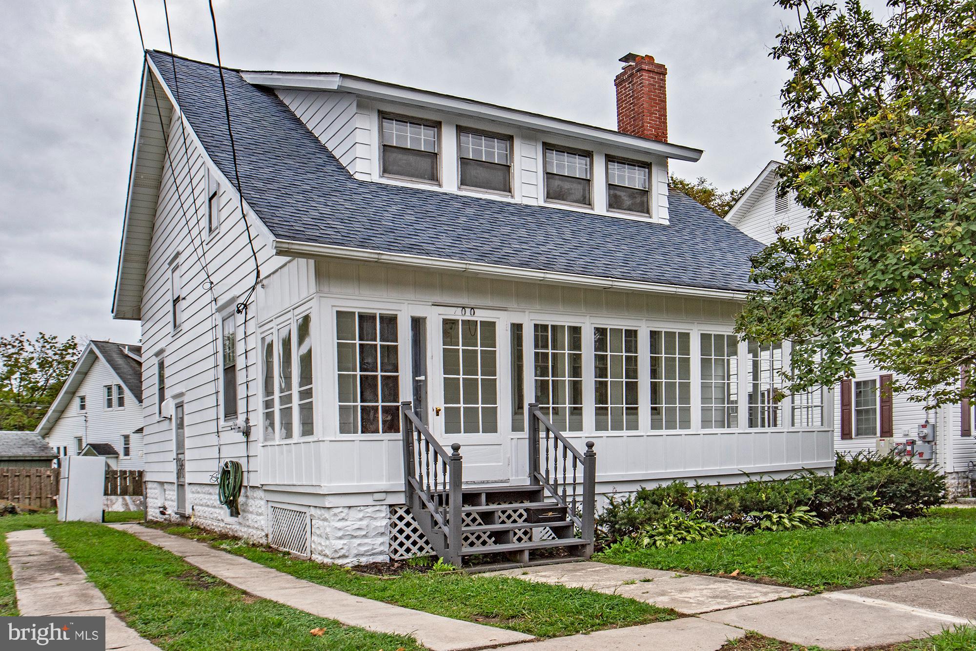 a front view of a house with a yard and potted plants