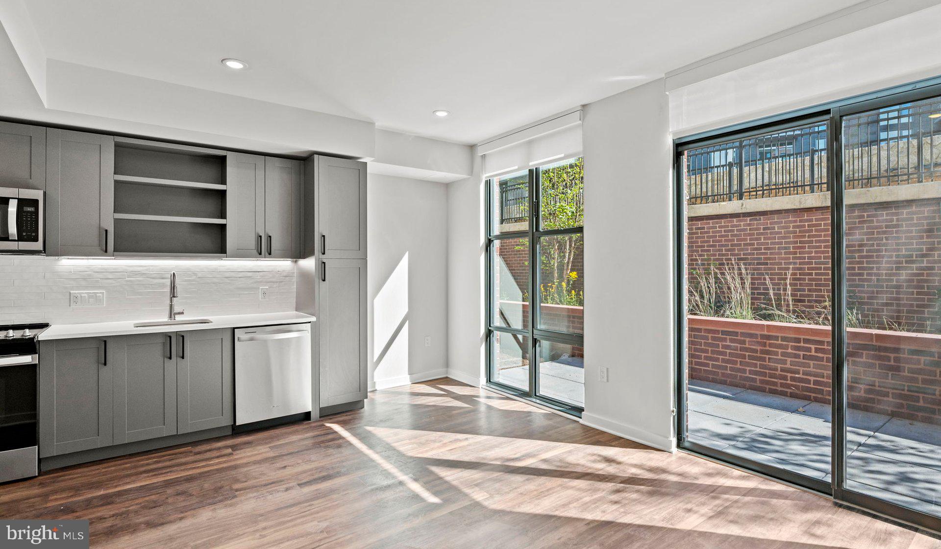 a view of a kitchen with kitchen island a sink windows and a refrigerator