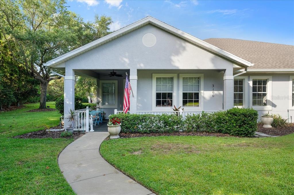 a front view of a house with a yard and potted plants