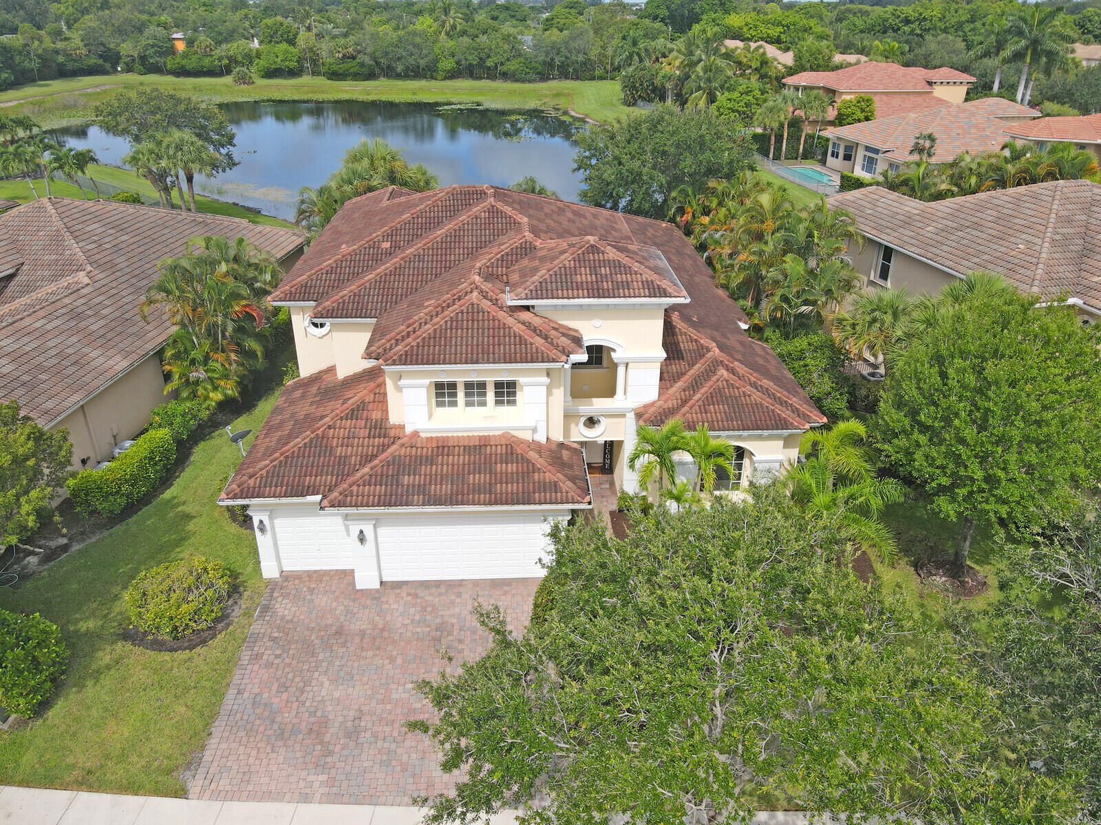 an aerial view of a house with a garden and lake view