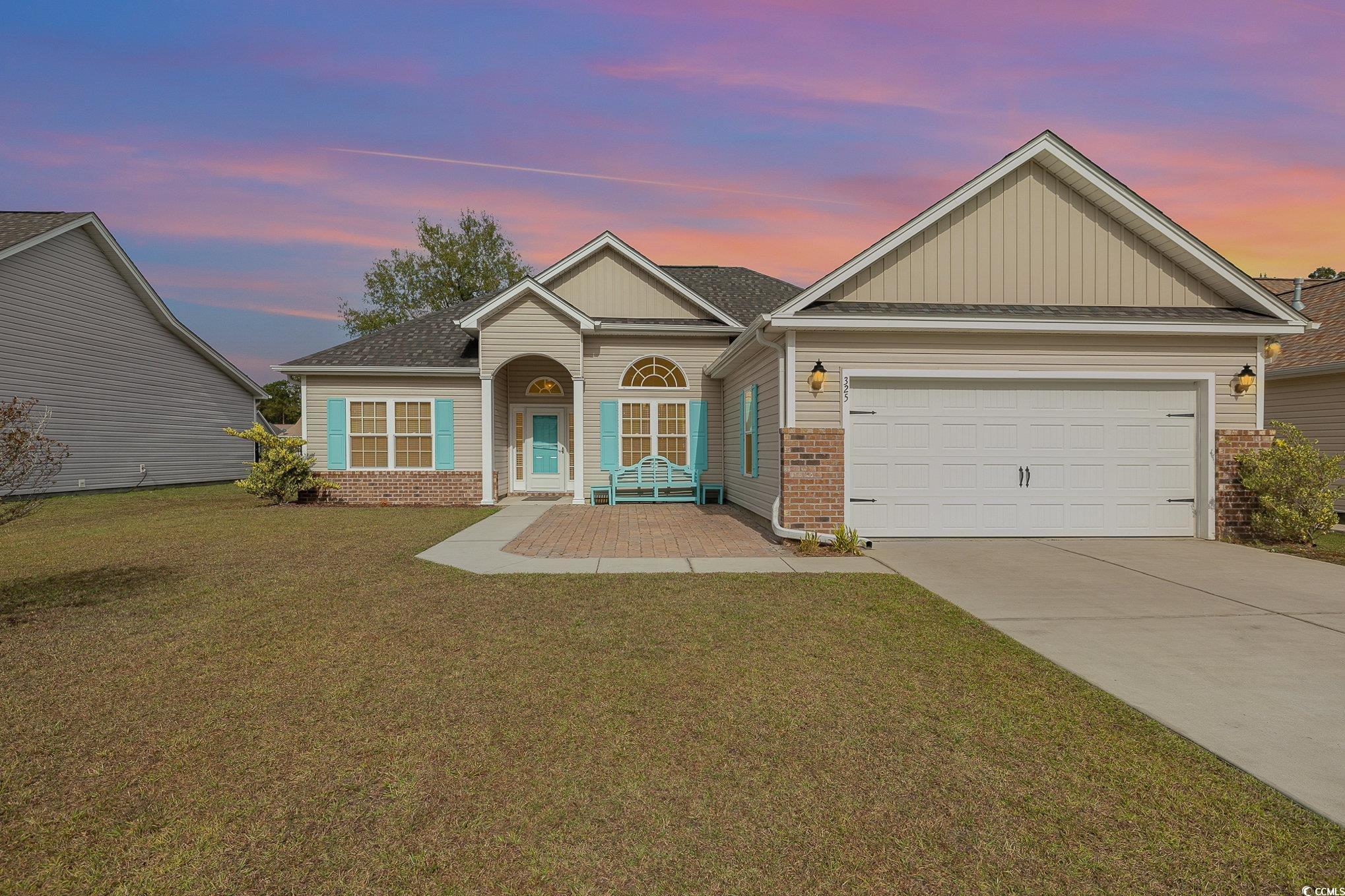 View of front of home featuring a garage and a yar