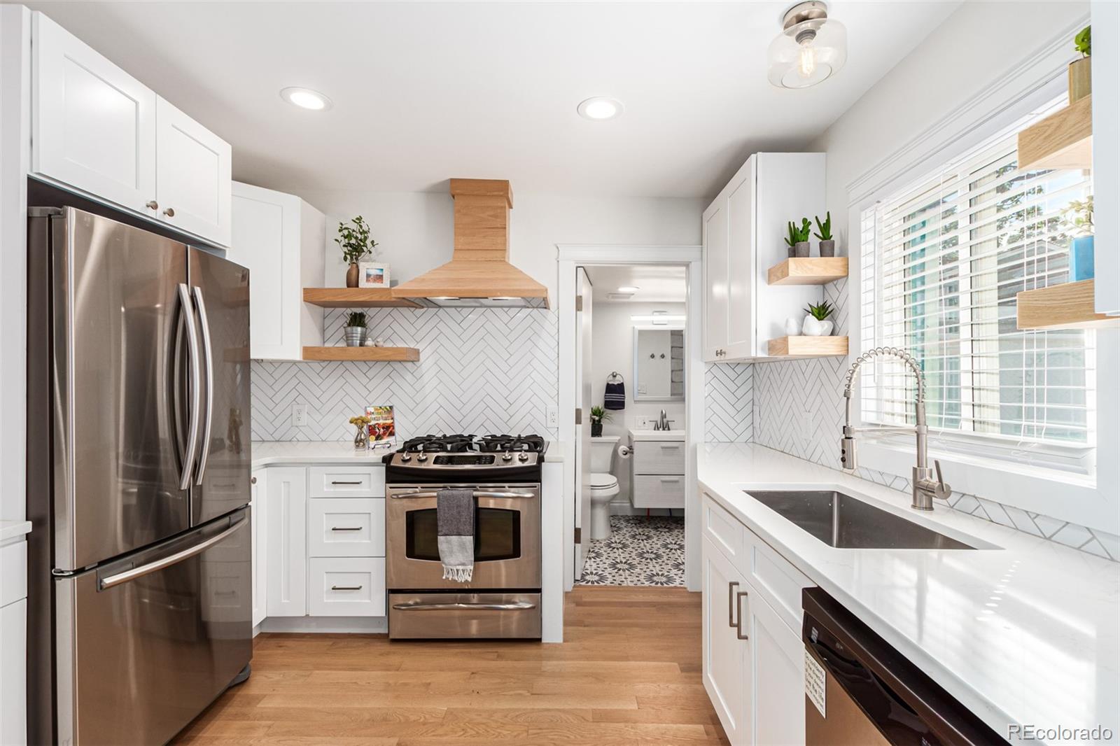 a kitchen with stainless steel appliances granite countertop a sink stove and refrigerator