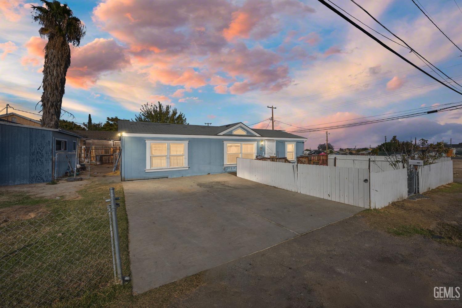 a view of a house with backyard and a tree