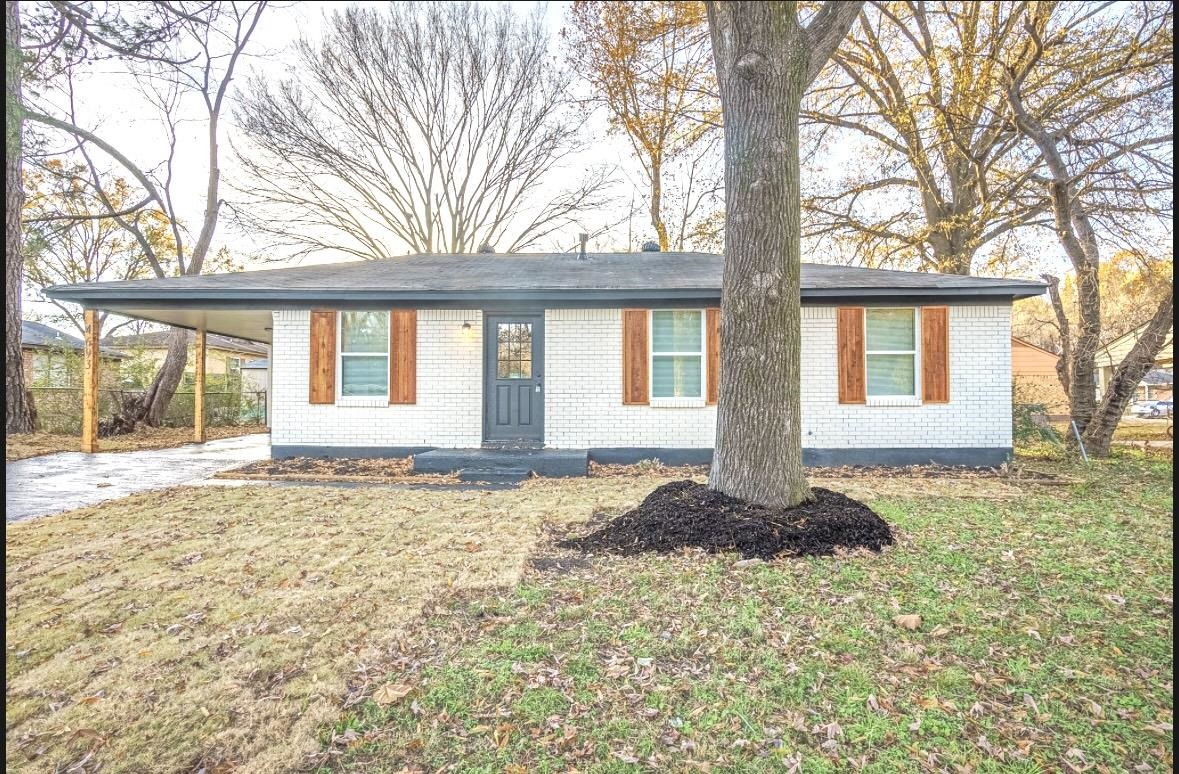 Single story home with a front yard and a carport