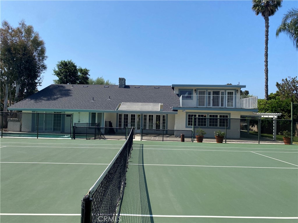 a view of a tennis ground with large trees