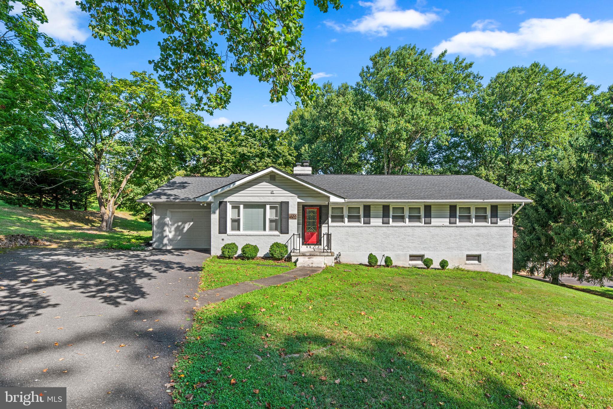 a front view of a house with a yard and trees