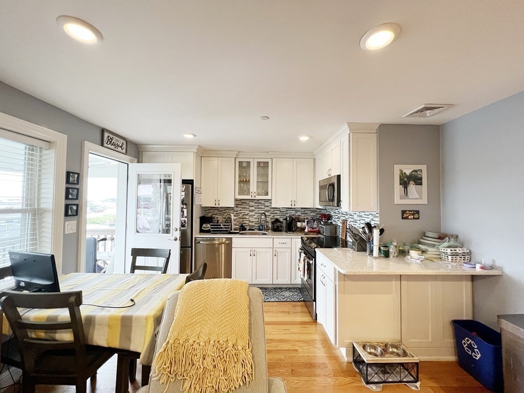 a kitchen with sink refrigerator dining table and chairs