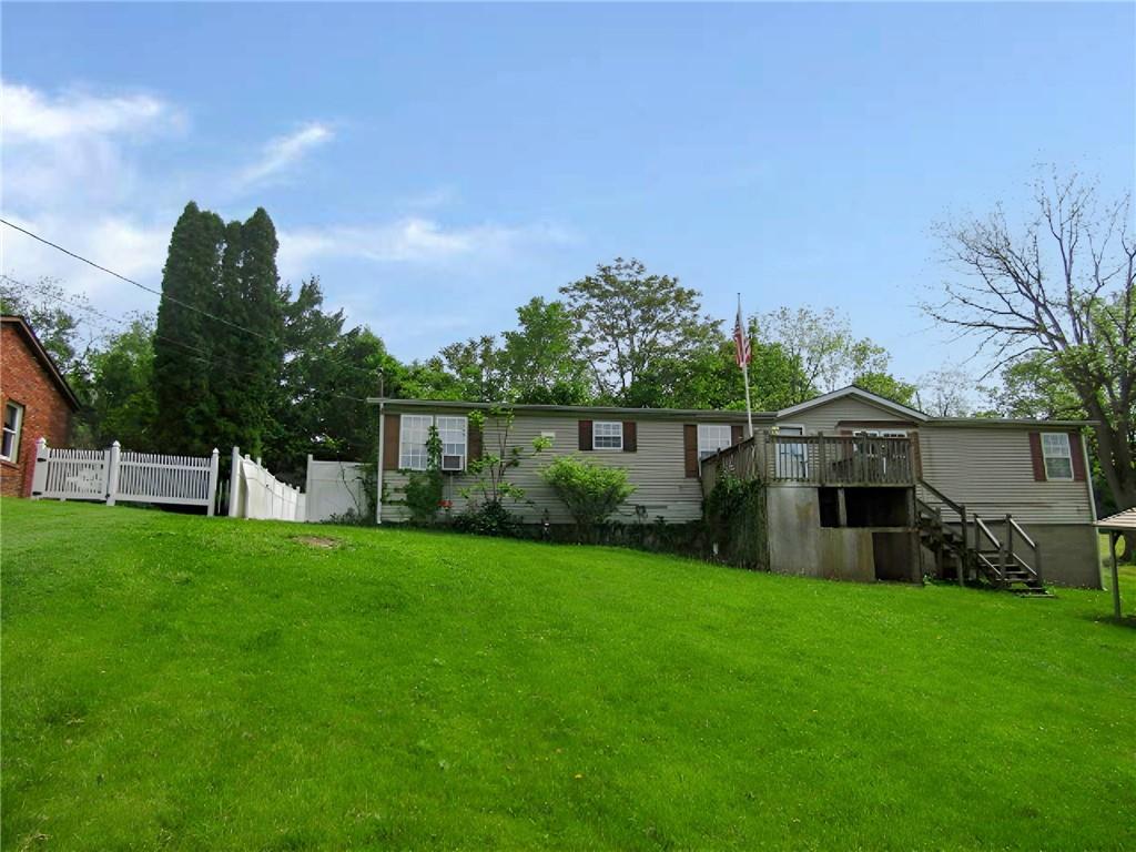 a view of a house with a yard and sitting area