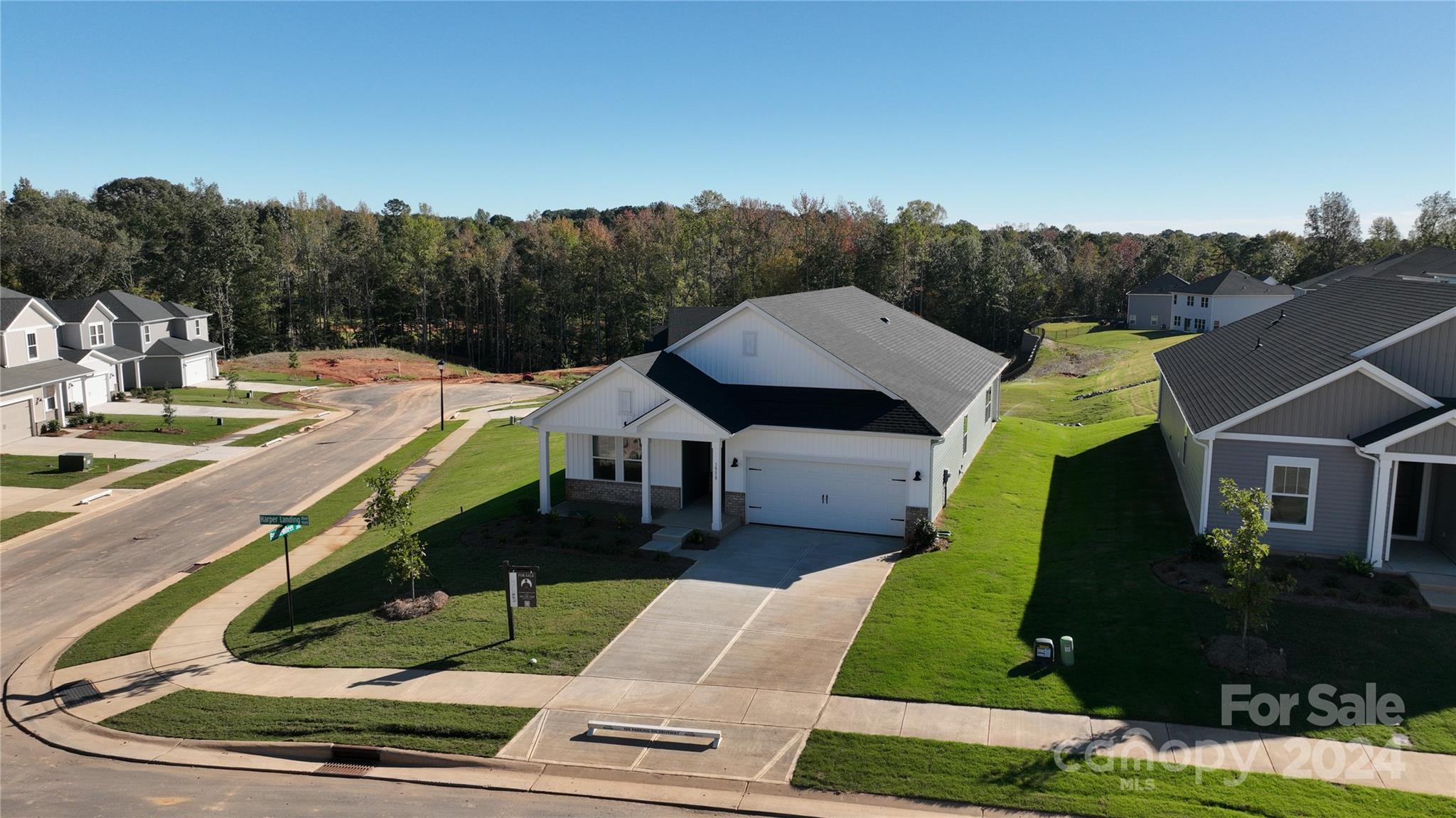 a aerial view of a house with swimming pool and trees in the background