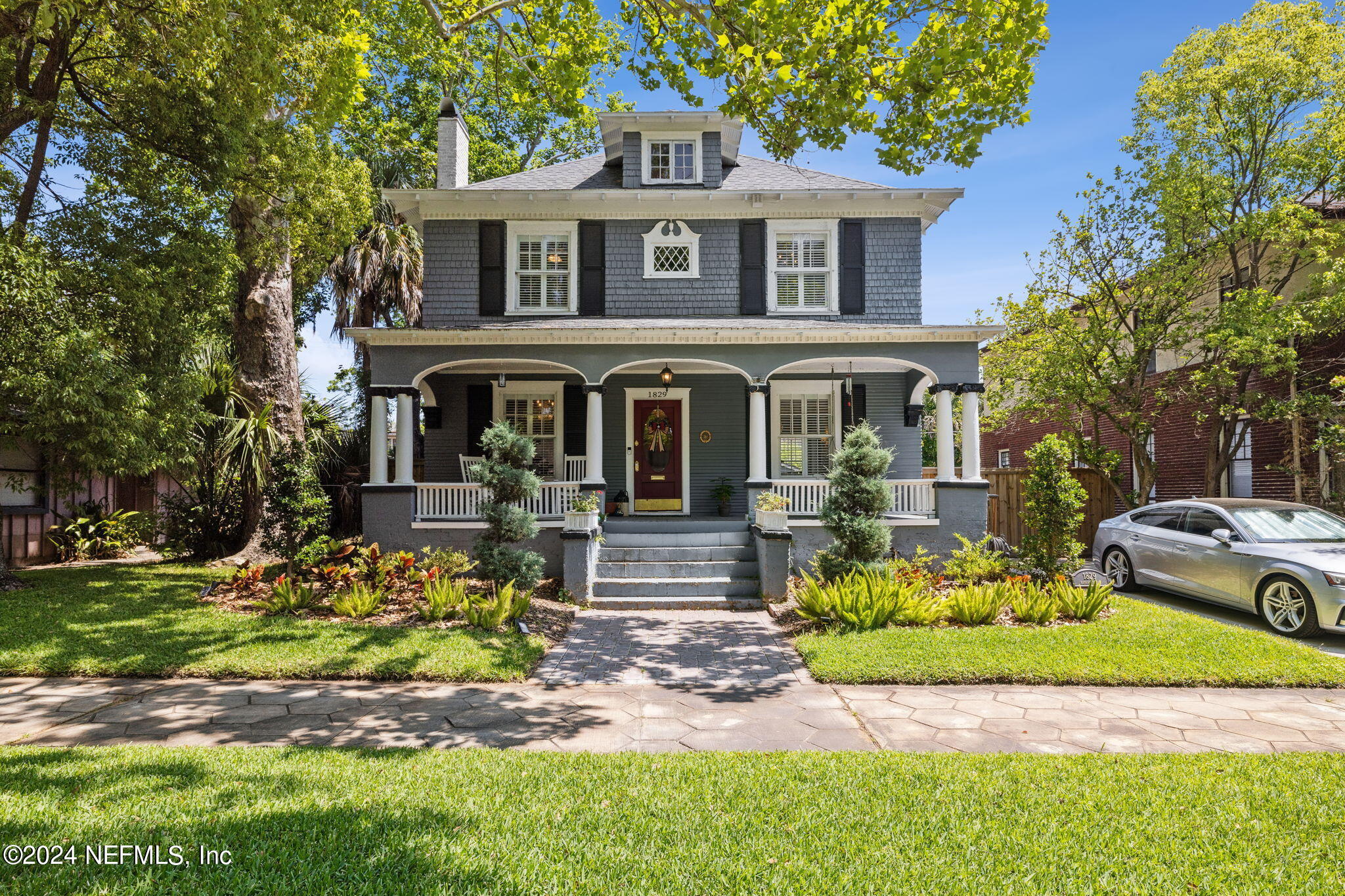 a front view of a house with a garden and plants