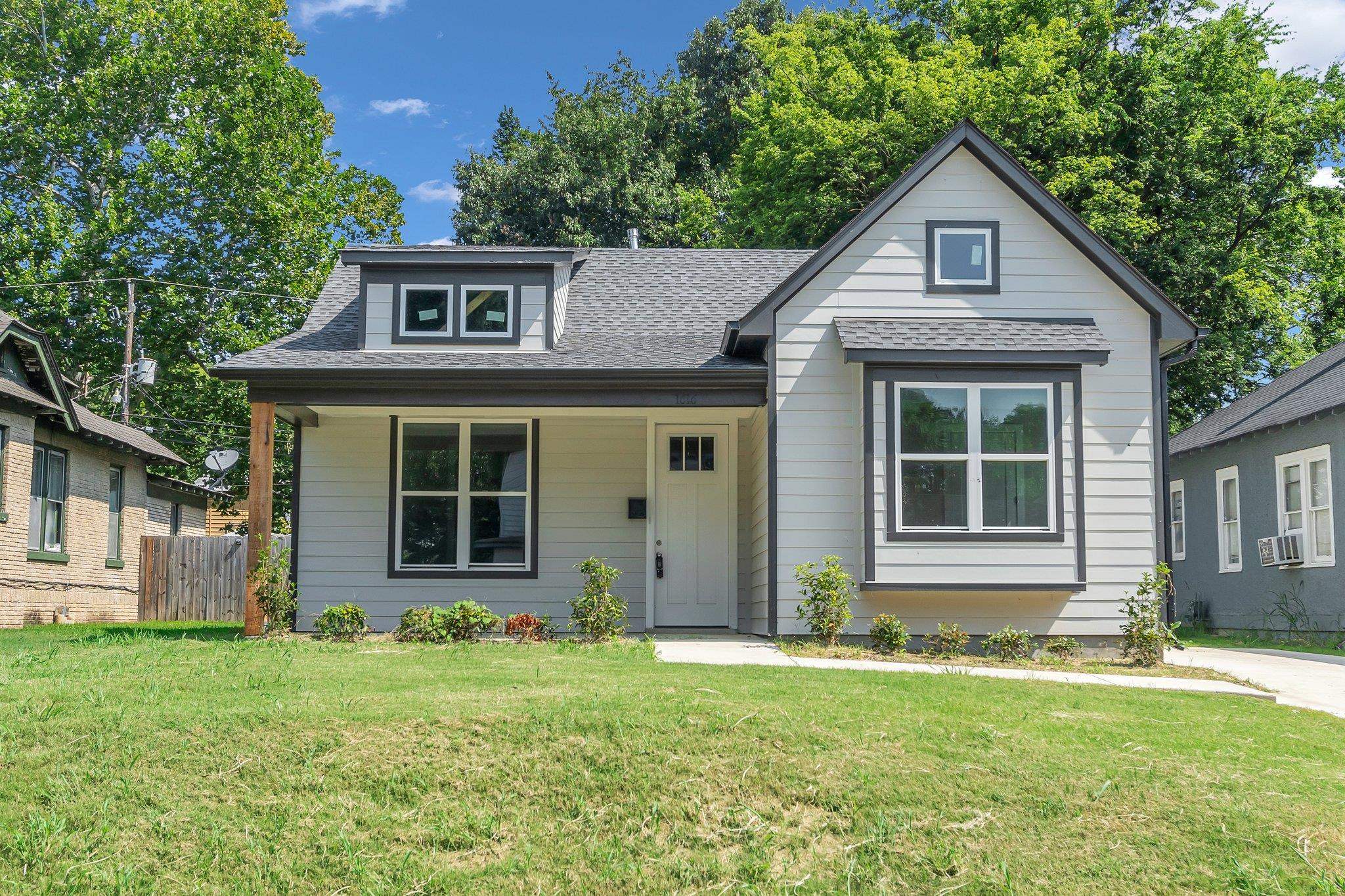 View of front of house featuring cooling unit and a front lawn