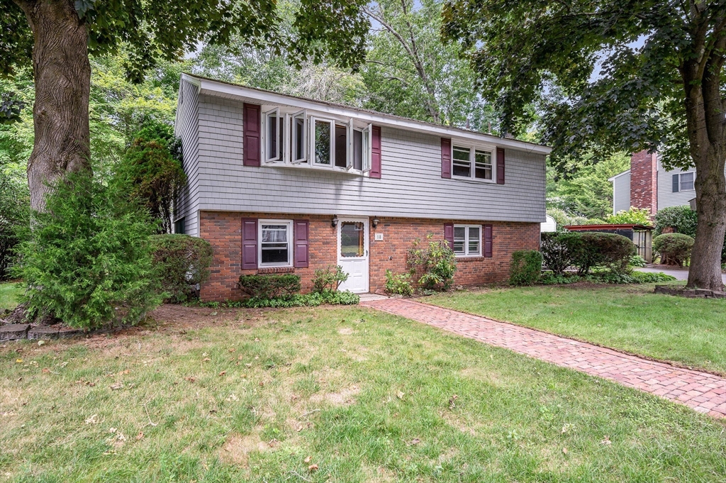 a front view of a house with a yard and trees