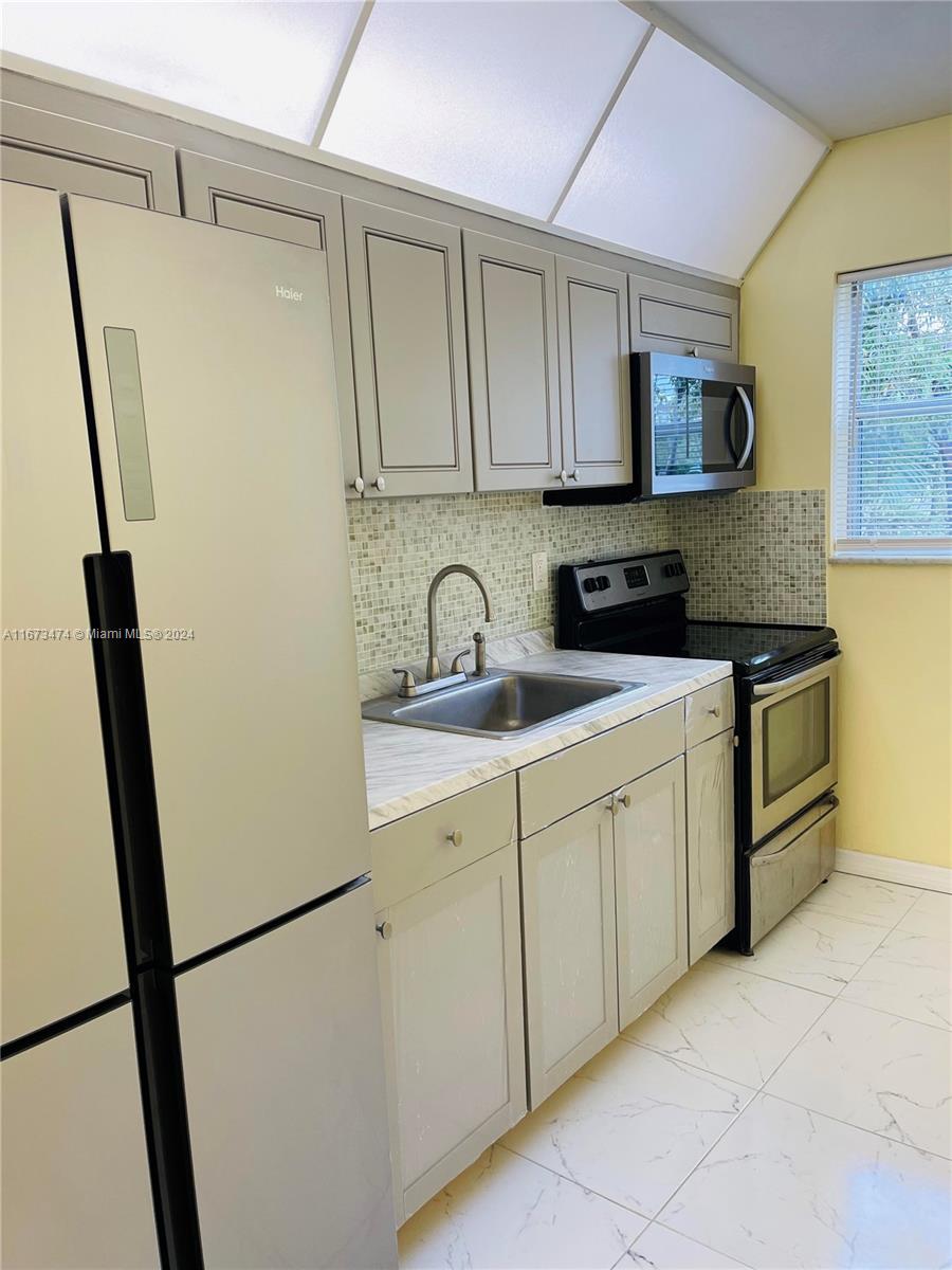 a kitchen with stainless steel appliances a refrigerator sink and cabinets