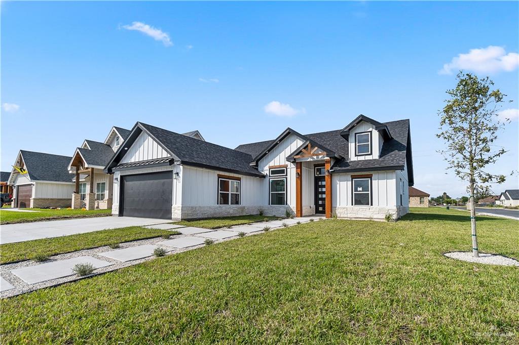 Modern inspired farmhouse with a front yard and a garage