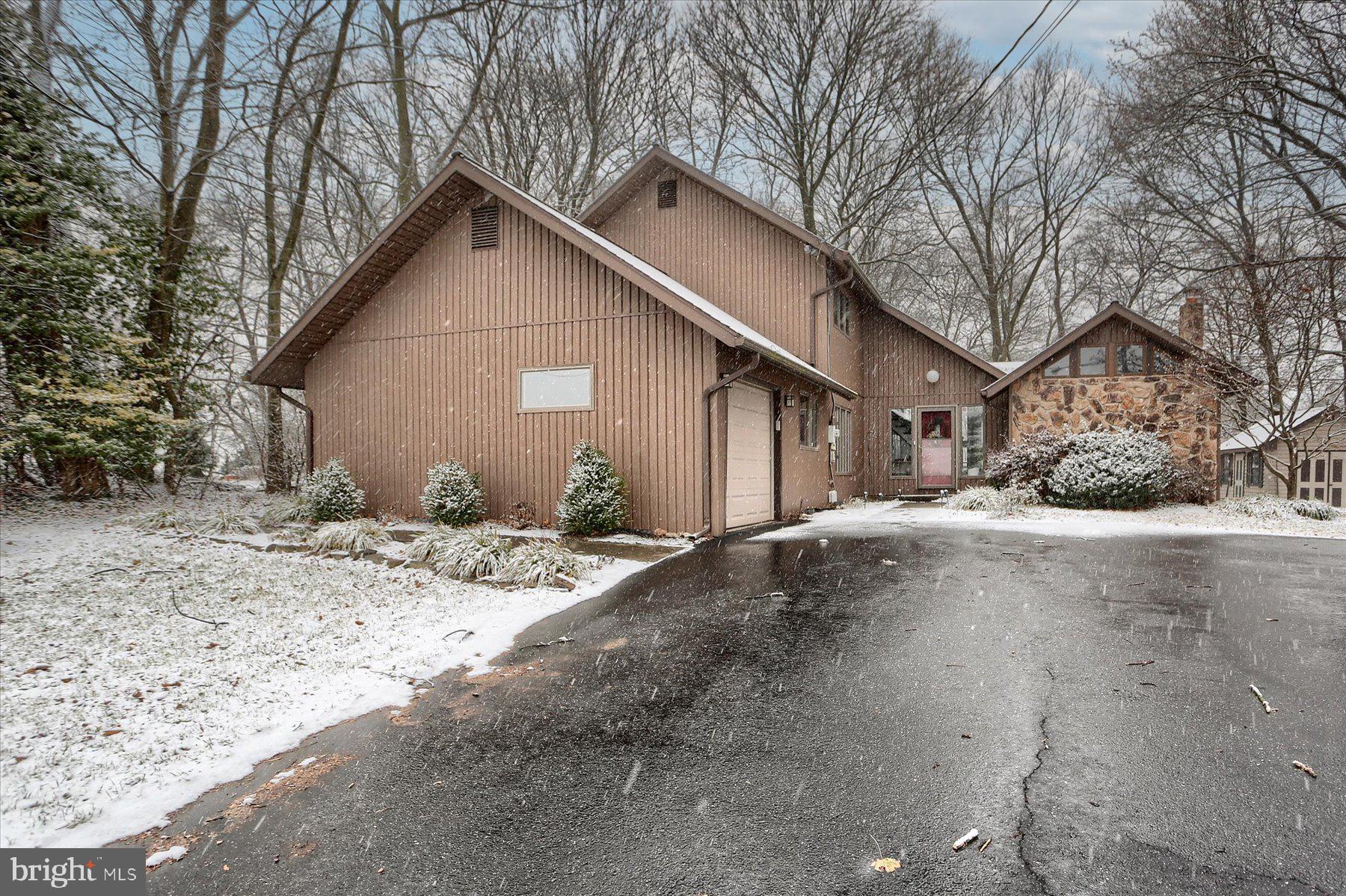 a view of a house with a yard covered the snow in the road