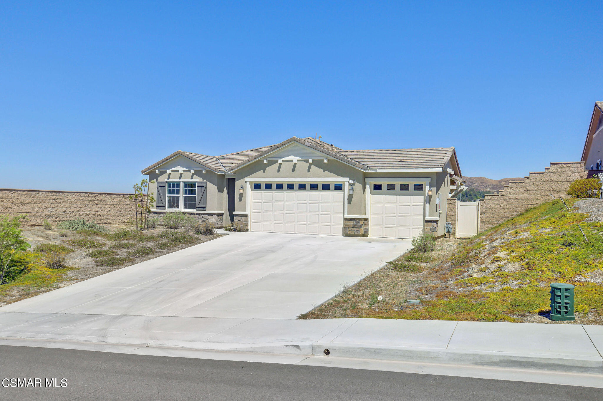 a view of a big house with a road and yard