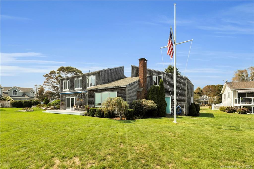 a view of a house with a big yard and large trees