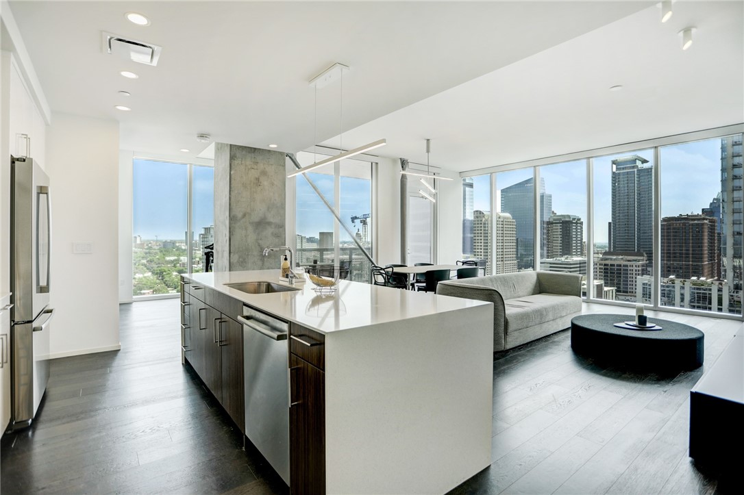 a large white kitchen with a large window and furniture