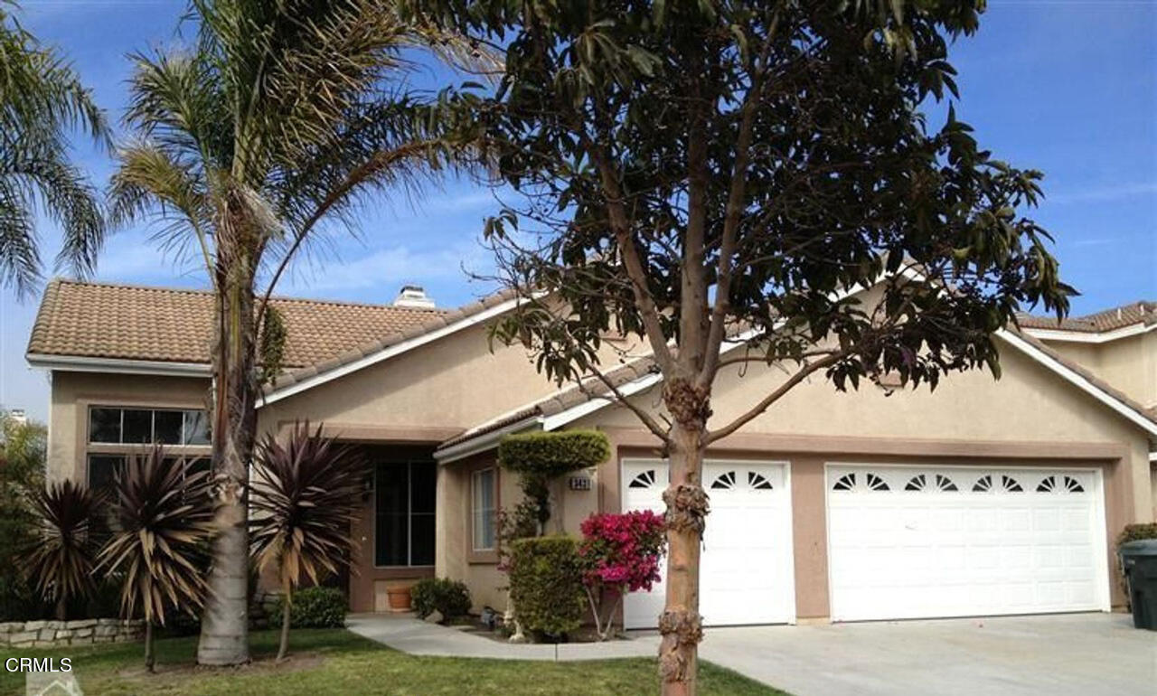 a front view of a house with a tree