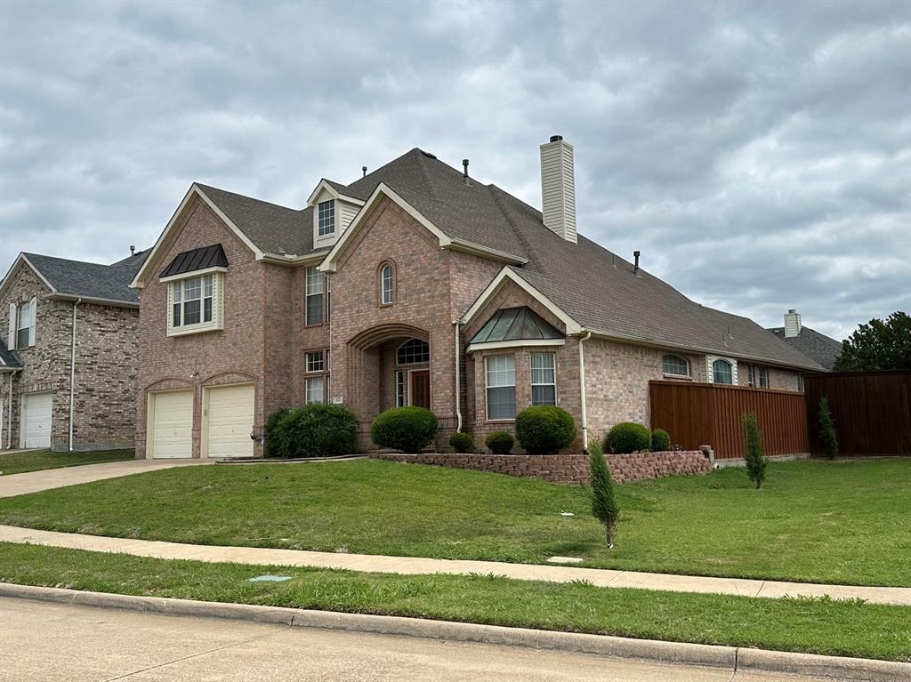 a front view of a house with a yard and plants