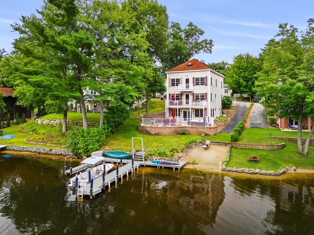 an aerial view of a house with swimming pool a yard and lake view