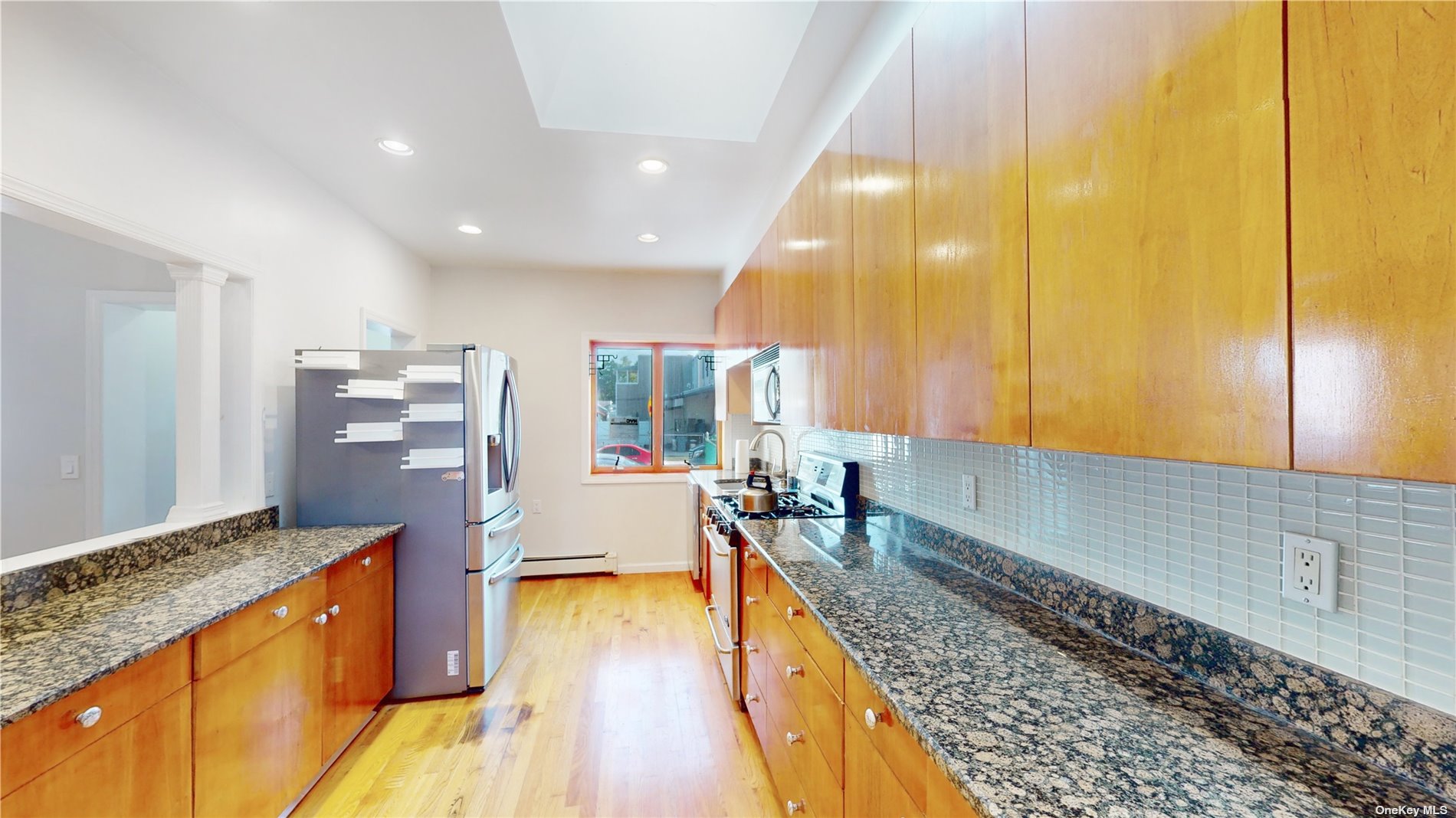 a large kitchen with stainless steel appliances kitchen island granite countertop a large counter top and wooden floors