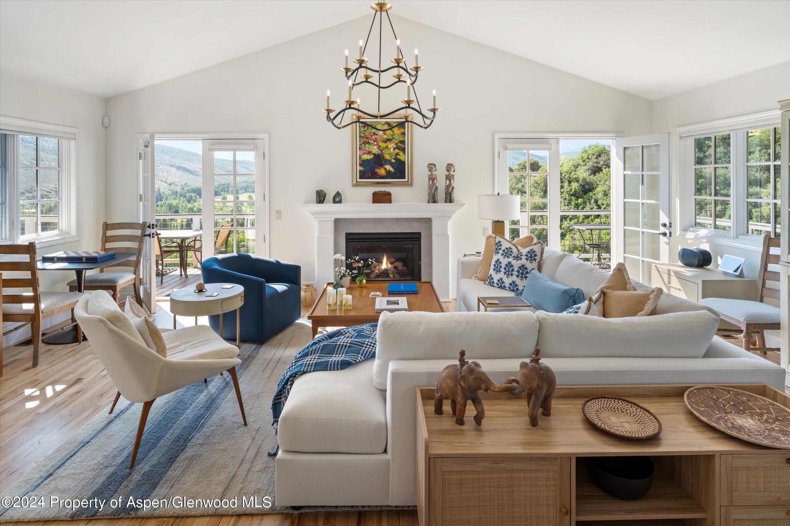 a living room with furniture a fireplace and a large window