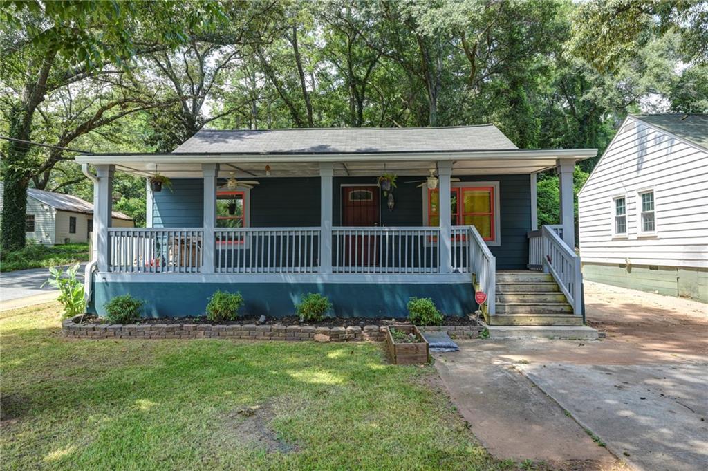 a front view of a house with a yard and potted plants