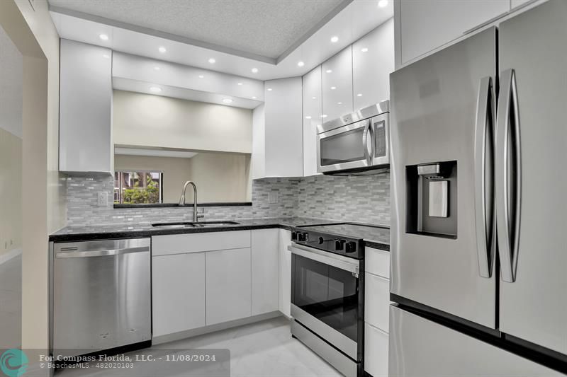 a kitchen with a sink and stainless steel appliances