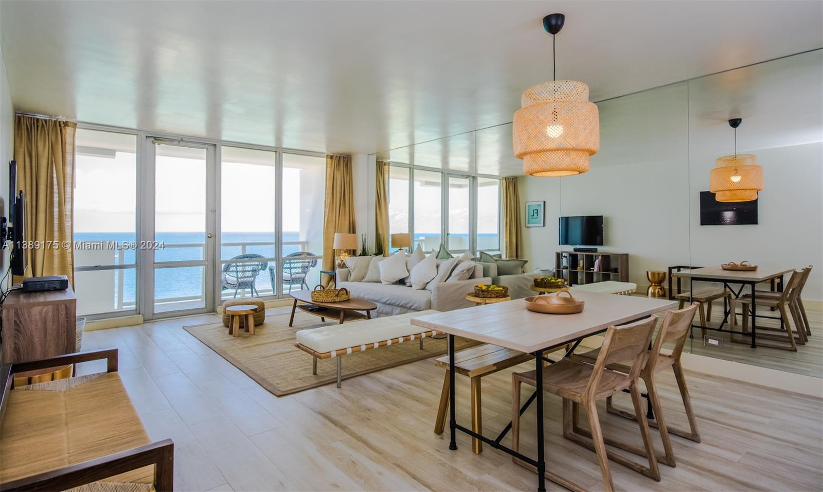 a view of a dining room and livingroom with furniture wooden floor a rug a chandelier